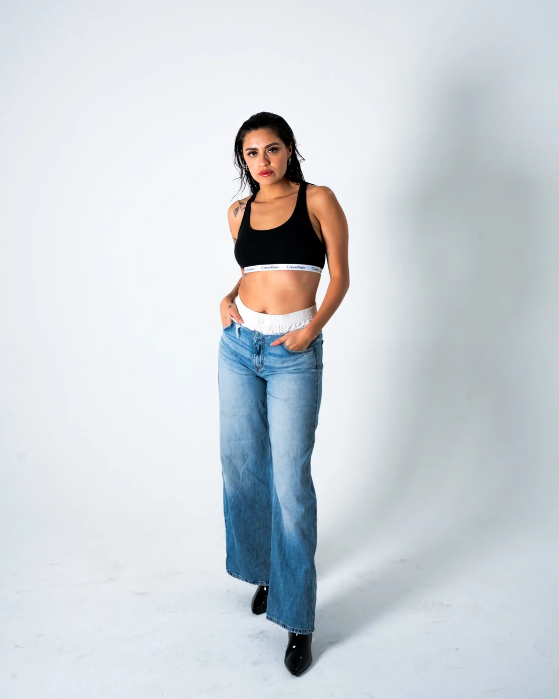 Full-length, black top and wide-leg jeans