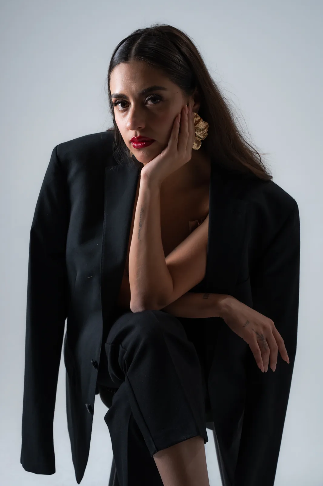 Andrea Maldonado in a black blazer, seated studio portrait